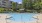 Sparkling Blue Swimming Pool with Lounge Furniture land Grilling Station